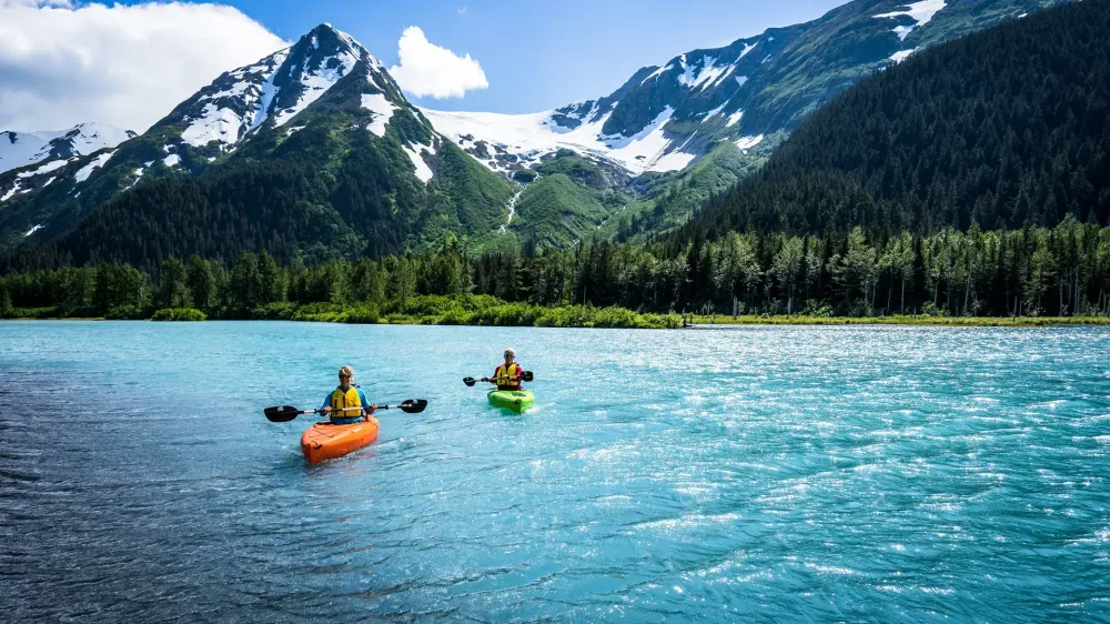 two people kayak in front of a glacier in anchorage alaska